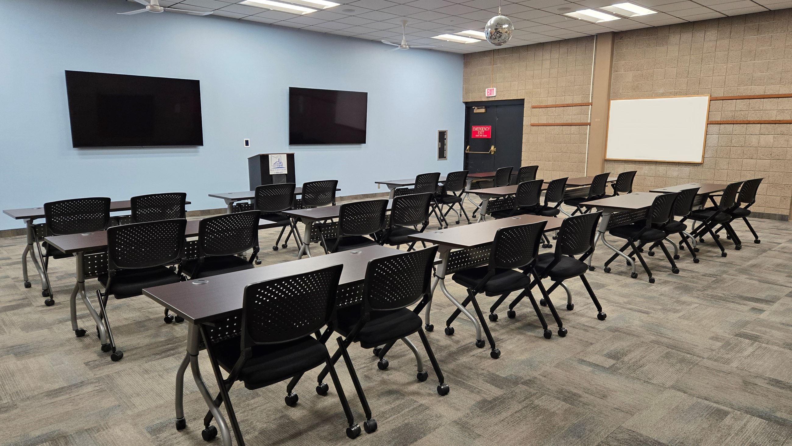 Auditorium with tables and chairs set up.